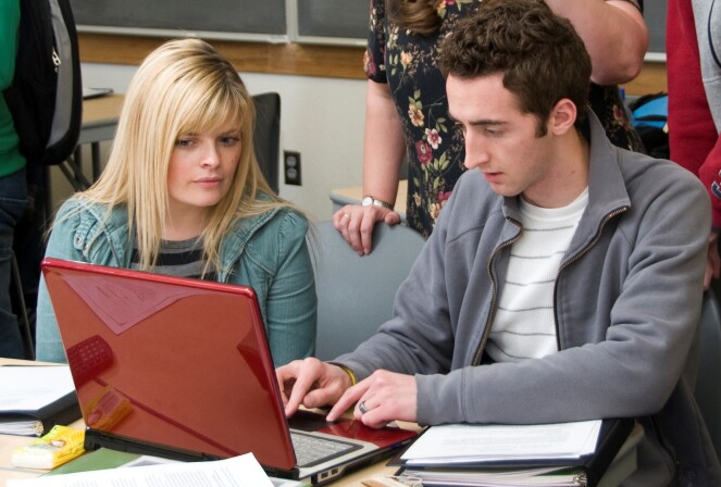 Students gather around a computer to complete an assignment for FDMath 110.