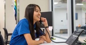 A student employee answers calls at the Mentor Hub to help new students transition to student life