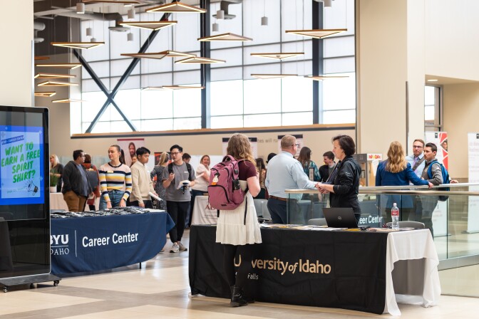 Students walking around, visiting career booths at the career fair.