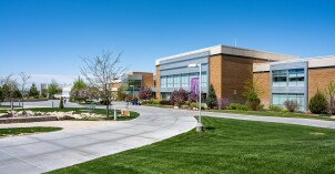 A springtime view of the Manwaring Center with green lawn, clear sidewalks, and blue skies.