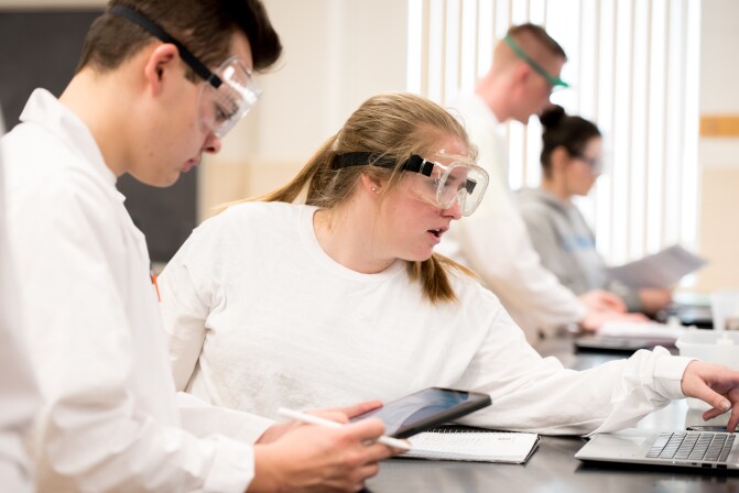 Students wearing protective goggles in the chemistry lab.