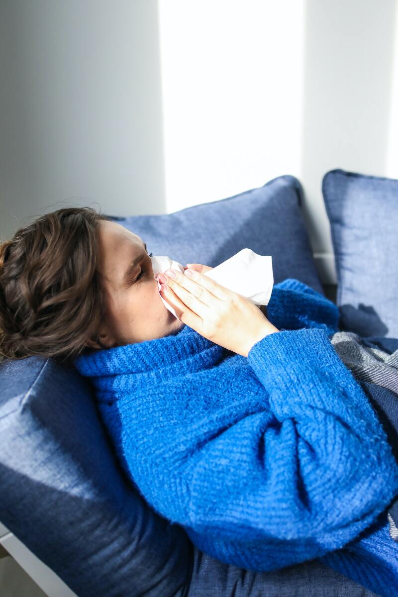 Sick lady blows her nose in bed.