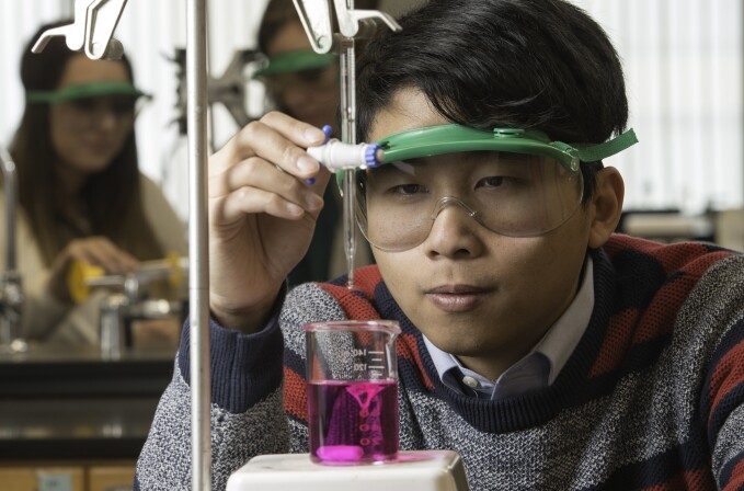 Chemistry Student mixes chemicals in an experiment.