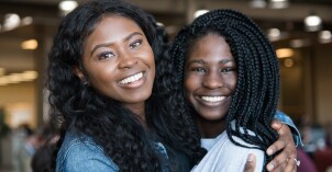 Two BYU-Idaho students hugging and smiling at the camera.