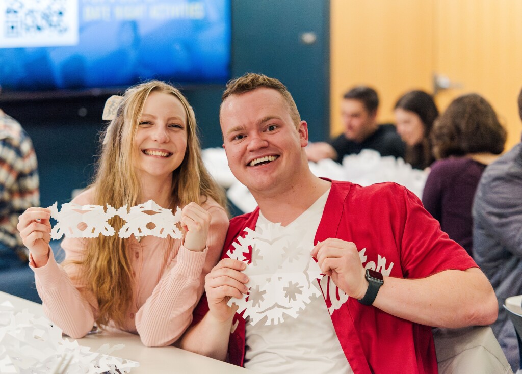 A student couple cutting paper snowflakes at Date Night