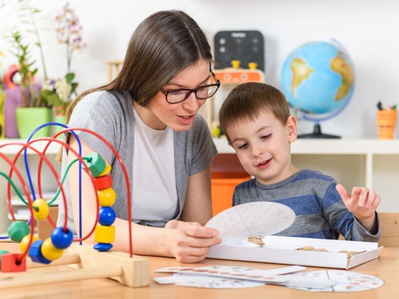 Teacher plays with a young boy.