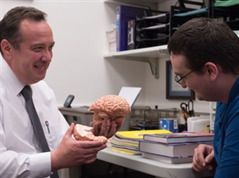 A professor discusses the human brain with a student.
