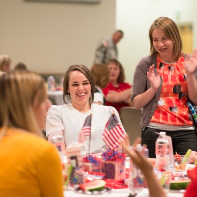 Women smiling and talking to one another at the Women's Luncheon.