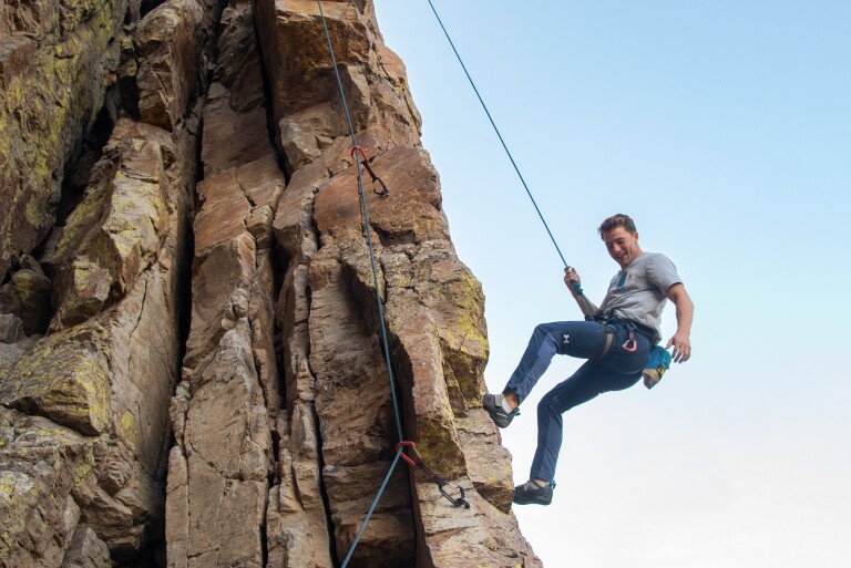 Student life at BYU-Idaho is adventurous. A student rappels down a local mountain in climbing gear.