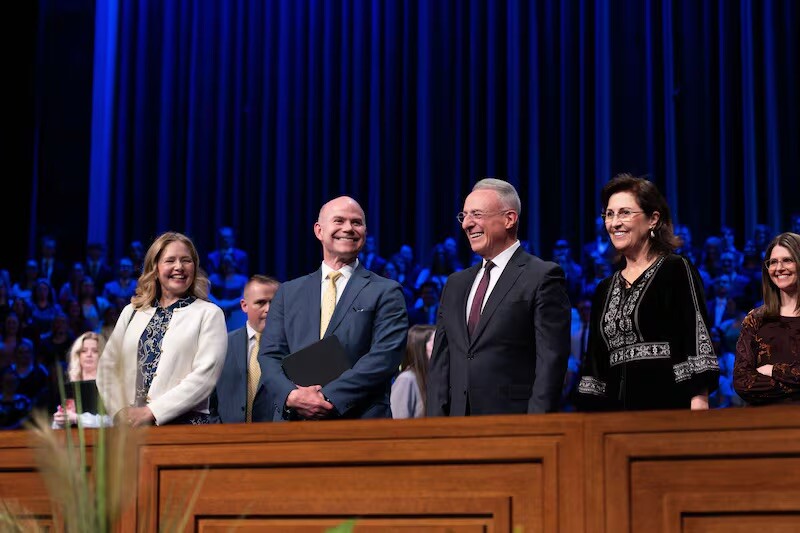 From left: Sister Jennifer Meredith, BYU–Idaho President Alvin F. Meredith III, Elder Ulisses Soares and Sister Rosana Soares wave to those gathered in the BYU–I Center for a devotional on Sunday, April 27, 2025.
