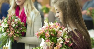 Two female students practice making bouquets in Ben Romney's Floral Design class
