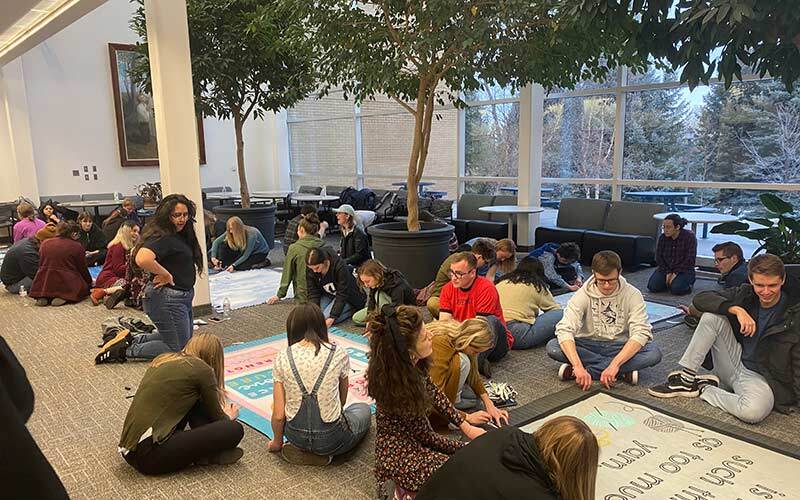 Students sitting on the ground working on the Blankets project groups