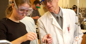 A BYU-Idaho chemistry teacher helps a student during a lab assignment.