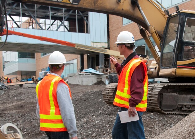 Construction Interns Aaron Howard (red jacket) and Ben Millet inspect the Manwaring Center.