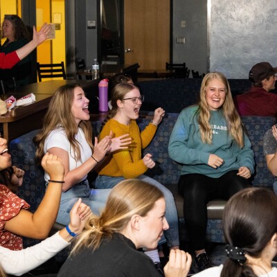 Nursing students cheering on a fellow classmate as they take their turn throwing the bowling ball down the alley