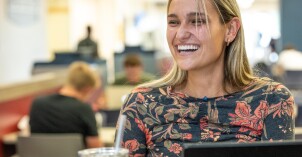 A student smiling while studying in the Manwaring Center