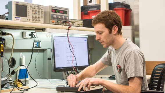 An Electrical Engineering student works with an electrical device.
