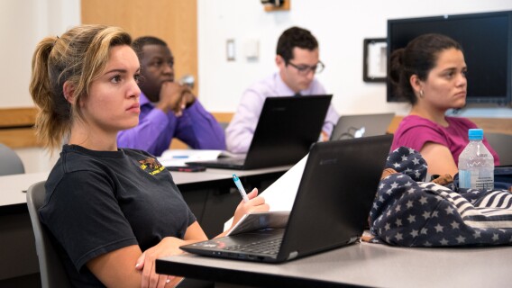 Students in their Research Methods class listen to their professor's lecture.