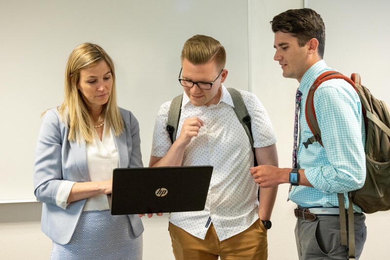 Accounting students talking with their professor.