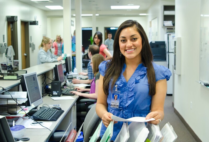 Smiling Health Center Employee ordering some documents