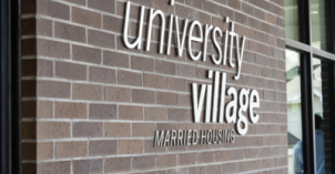 An outside view of the University Village married housing signage on a brick wall of the housing building at BYU-Idaho.