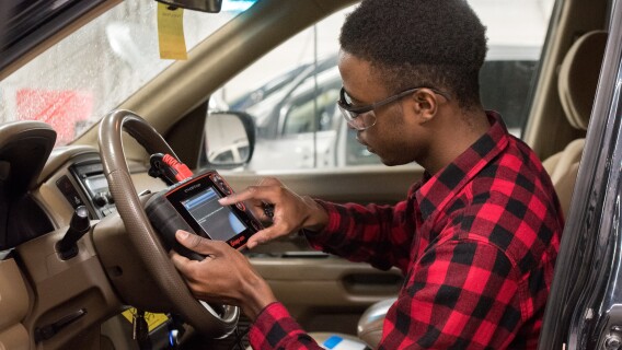 A student works on a car in an Advanced Vehicle Systems Lab.