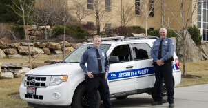 Campus Security officers standing outside their parked car