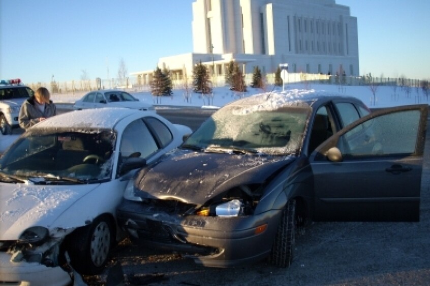 A pictures of two cars that had just been in a collision due to icy winter roads.