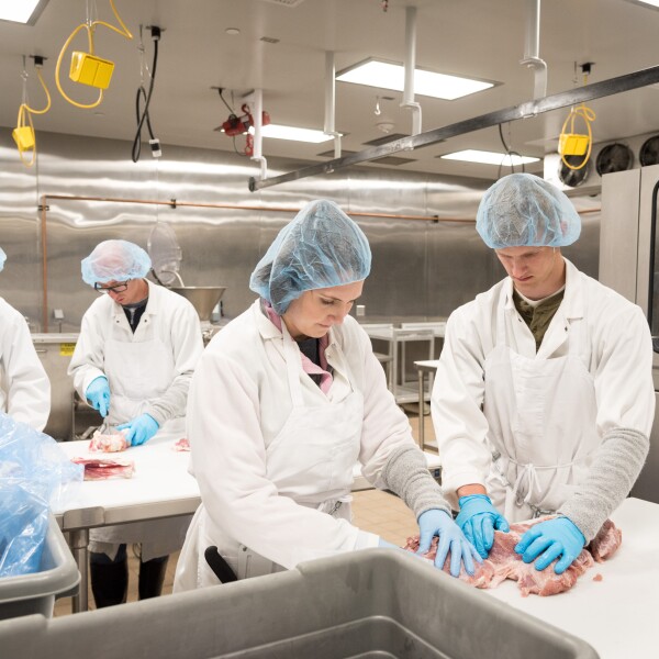 Students trimming meat.