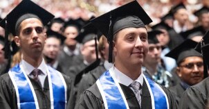Students standing in their caps and gown at Commencement