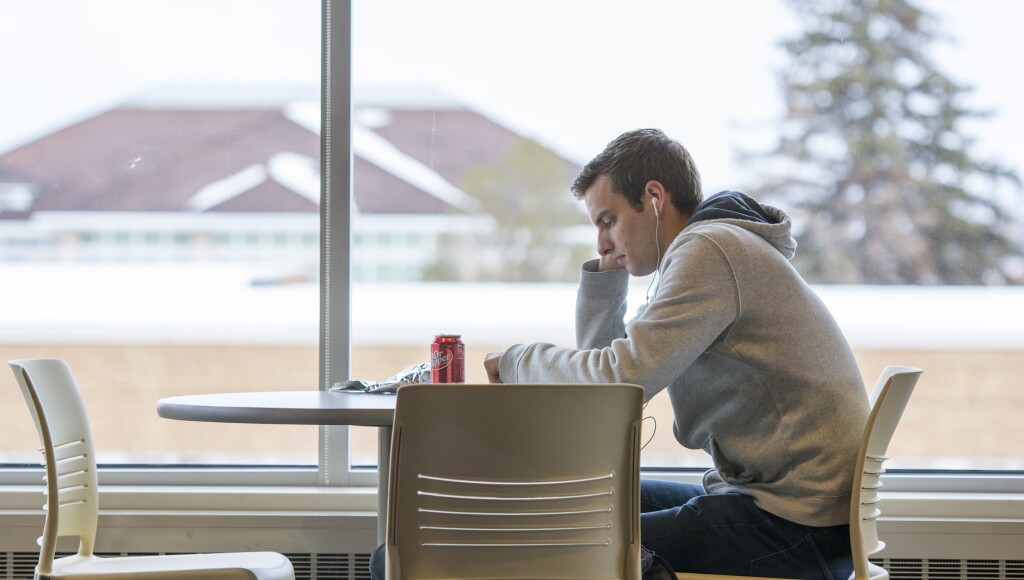 Student pondering with his headphones in the Crossroads