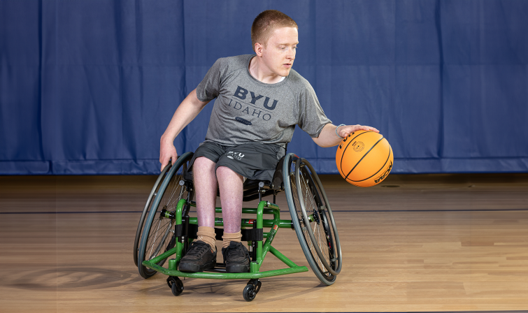 Male student in a wheelchair playing basketball.