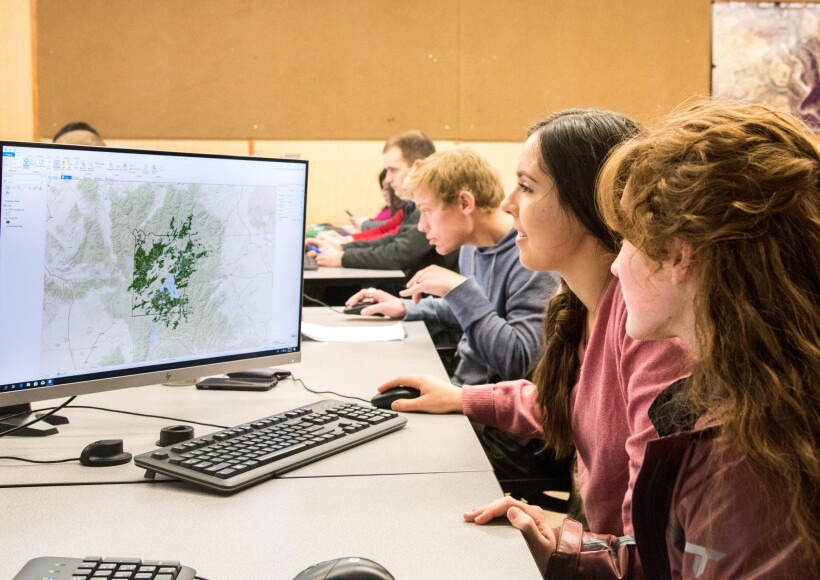 Students working on desktop computers in a geology class