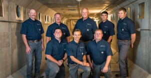The mechanical service staff poses for a photograph in an underground hallway on the BYU-Idaho campus.