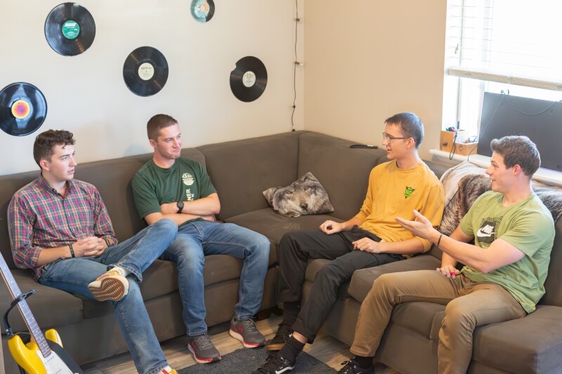 Four boys discussing problems and solutions for the apartment