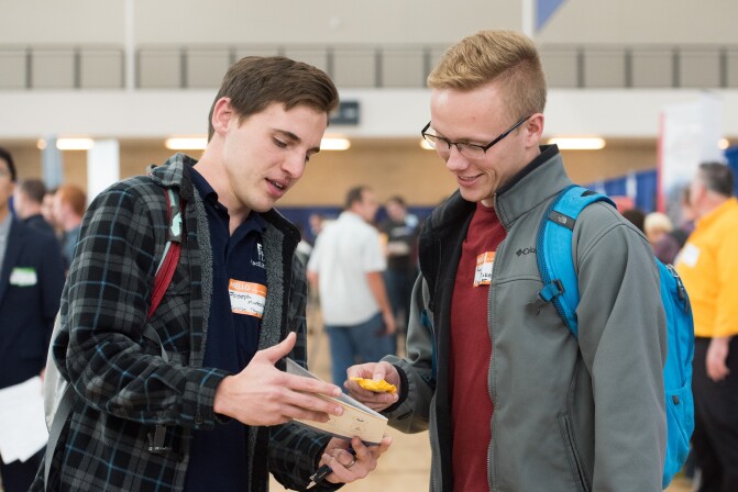 Two male students talk during a career fair at the Taylor Building on BYU-Idaho campus in October 2018.