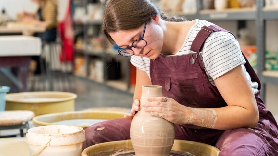Ceramics student Whitney Carr throwing on the wheel.