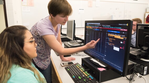 Students work on an assignment with the help of a Bloomberg computer.