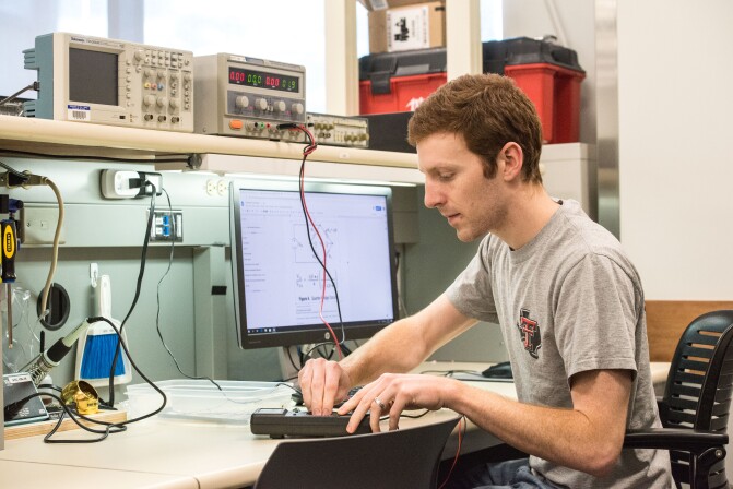 An Electrical Engineering student works with an electrical device.