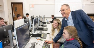 An economics teachers helps a student.