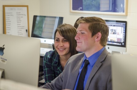A male and female student work on the computer