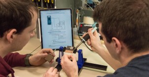 A BYU-Idaho student soders an electrical device during an electrical engineering internship.