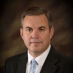A portrait photo of Derick Rhoton