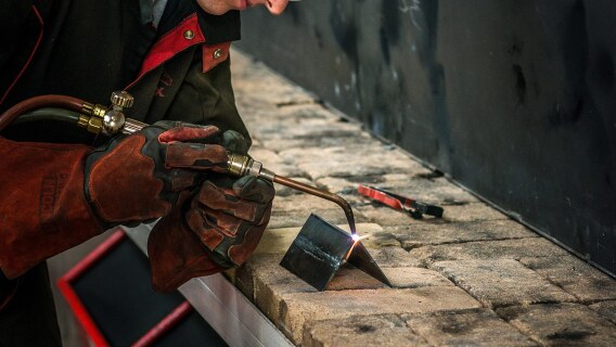 Welding student and a Lincoln Electric arc welder.