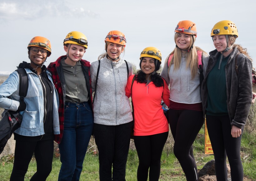 Six BYU-Idaho students smile together before they explore a cave during a THRIVE activity.