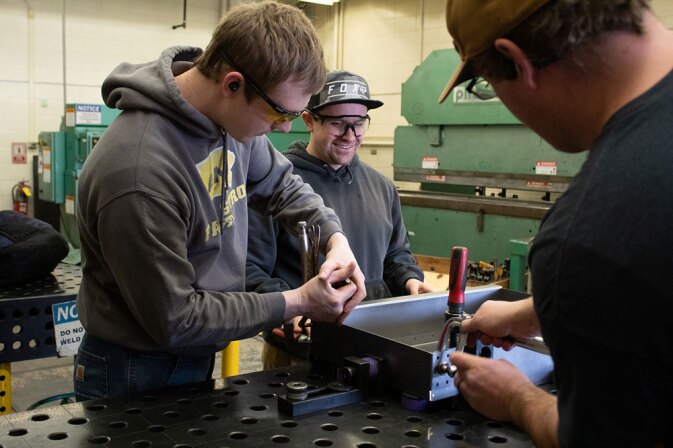 Students were protective glasses and use various tools to complete a project in the shop.