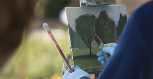 Brother Bodily gives a painting demonstration during his Oil Painting class outside the Spori Building.