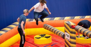 BYU-Idaho students jump over obstacles in a blow-up obstacle course as part of a campus I-Night event.