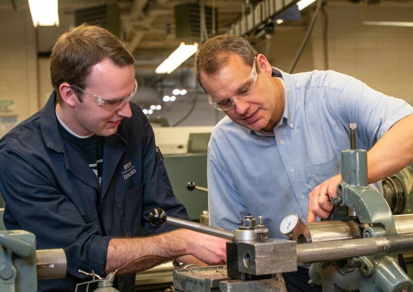 A teacher guides a BYU-Idaho student in the shop
