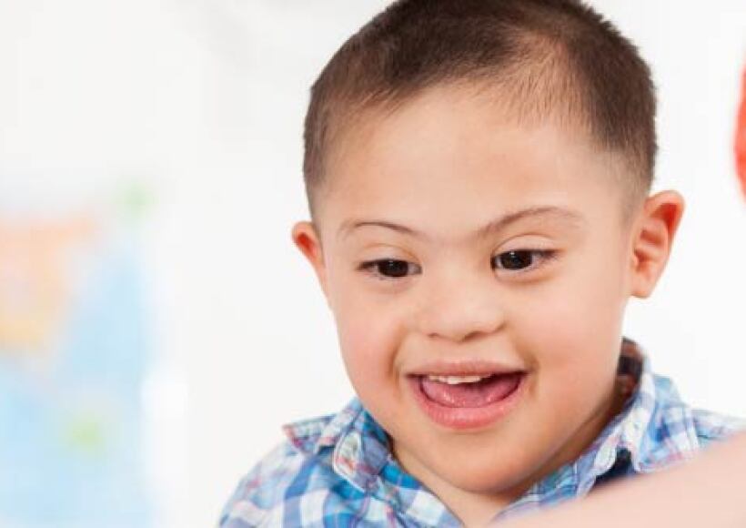 Teacher helps teach a student with down syndrome.